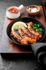 Delicious homemade baked sausages in a frying pan.