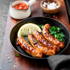Delicious homemade baked sausages in a frying pan.