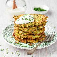 Zucchini fritters, vegetarian zucchini pancakes, served with fresh herbs and sour cream.