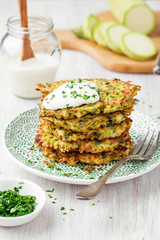 Zucchini fritters, vegetarian zucchini pancakes, served with fresh herbs and sour cream.