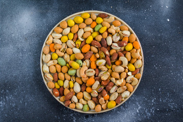 Nuts in bowls on the table, almonds, cashews and coasted nuts on the blue background.