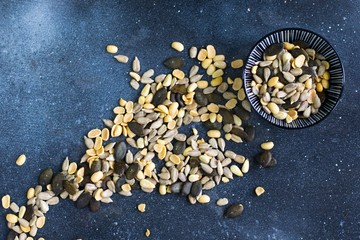 Sunflower and pumpkin seeds  in bowl on the blue background.  Large group of seeds. Snack and appetizer. 