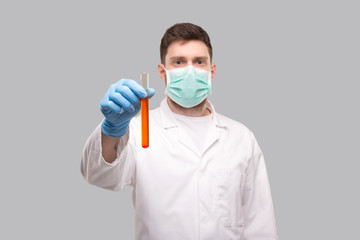 Male Doctor Showing Blood Analysis Wearing Medical Mask and Gloves. Laboratory Virus Concept. Red Liquid