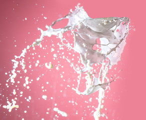 Splashing milk on a pink background.
