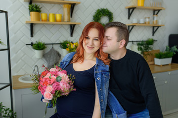 Pregnant couple have fun at home in the kitchen during quarantine