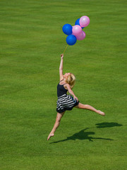 Woman holding ballons jumping