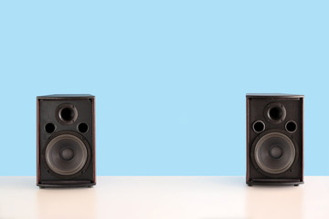Two audio speakers box on a white table with sky blue color background