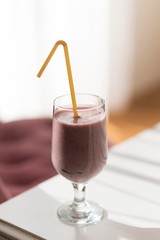 glass of banana and raspberry smoothie isolated on table