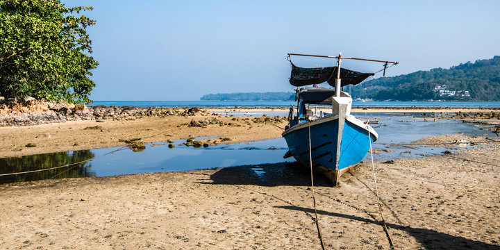 Motor boat on the beach at low tide