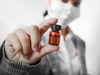 Asian female doctor holding medicine bottle for injection. Medical glass vial for vaccination, liquid drug or vaccine from treatment, Healthcare and medical concept