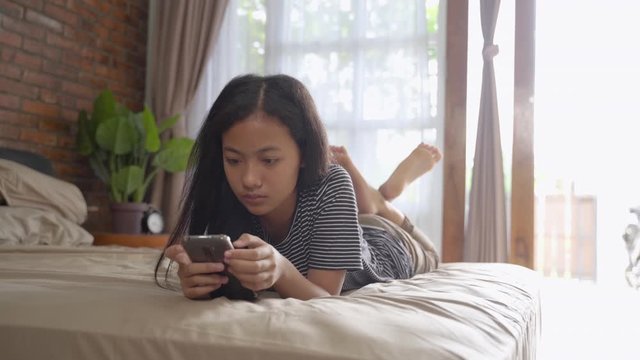 peer pressure. young teenage asian girl shocked while using her mobile