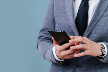 A man in a suit holds a phone