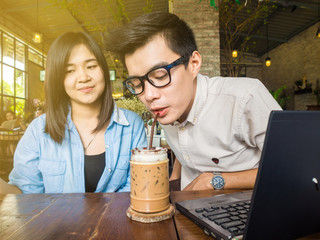 Asian business couple discuss business plan with laptop