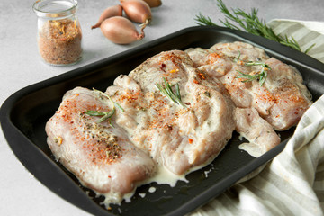 chicken breast under a marinade on a baking sheet