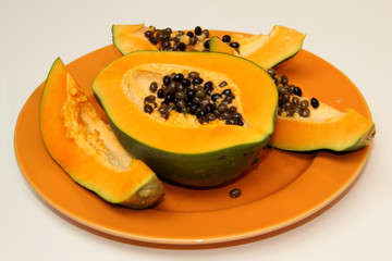Papaya slice at the orange plate. Appetizer asian and diet food. Wallpaper and background.