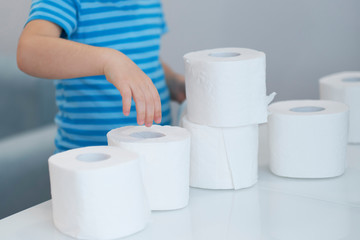 Active boy playing with toilet paper in retro filter,kid boy looking through toilet roll,Child hugs a bunch of toilet paper, Children health care concept