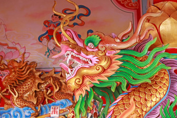 Head of a gold and green dragon statue at an old Chinese Buddhist temple in southeast Asia