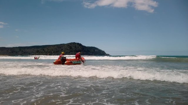 Lifeguards launching an IRB in the surf