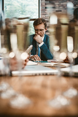 Business man looking at tablet before drinking champagne