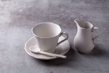Obraz na płótnie Canvas Teapot creamer, Cup and saucer on Cement Board