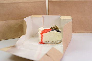 Fototapeta na wymiar Delicious cheesecake in eco packaging, food and dessert delivery concept.