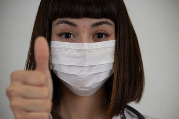 A asian young girl that infected by coronavirus makes positive sign as 	treatment. 