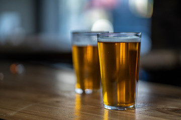 two pints of beer one in focus other not