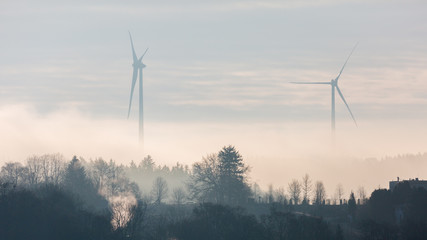 Starnberg, Bavaria / Germany - Mar 31 2020: Silhouette of two wind turbines at dusk. Located close to Lake Starnberg (Starnberger See). Producing energy for bavarian households. Panorama format.