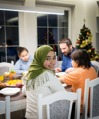Muslim interreligious family with christmas tree in background