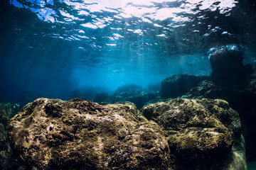 Underwater scene with stones and sunlight in ocean