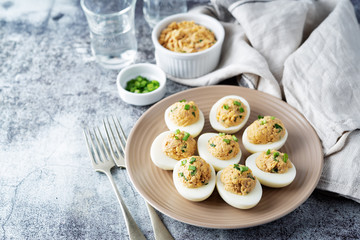 Canned Tuna deviled eggs with scallion on a light background