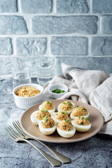 Canned Tuna deviled eggs with scallion on a light background