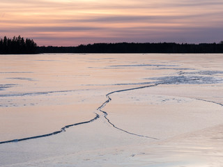Frozen lake landscape with cracked ice cover