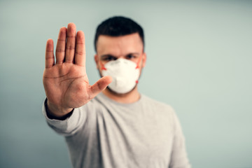 A man is putting on a protective mask. Respiratory protection from coronavirus. Personal protective equipment for a pandemic of a viral infection. Covid-19.