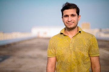 Young handsome Persian man against view of the city