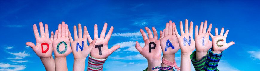 Kids Hands Holding Colorful English Word Do Not Panic. Blue Sky As Background