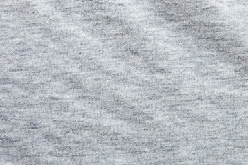 Close up shot to see the detail of heather grey knitted fabric made of synthetic fibres background. abstract wallpaper clothing or soft textile with copy space for text.