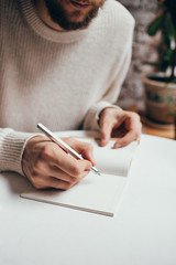 man writing a notes in notebook