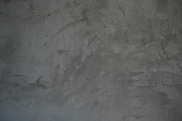 Dark grey cement wall with random grunge textures from brush strokes on surface.  Renovation, decoration ideas for background and building objects.