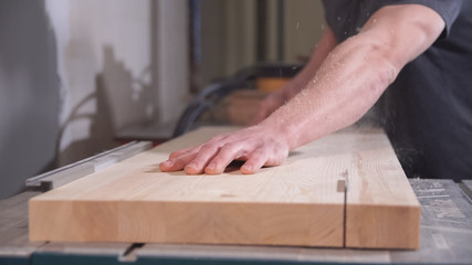 Worker using circular saw for cutting wooden board. Accuracy and concentration concept.