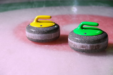 curling stones on ice near the home colorful background