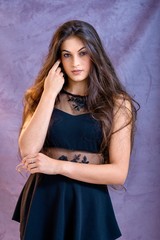 Fototapeta premium black hair woman portrait with brown eyes on a gray background , Caucasian ethnic group is looking into the camera with a serious expression on her face. White girl with long black hair and brown eye