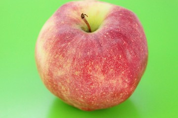 Red beautiful juicy apple located on a green background