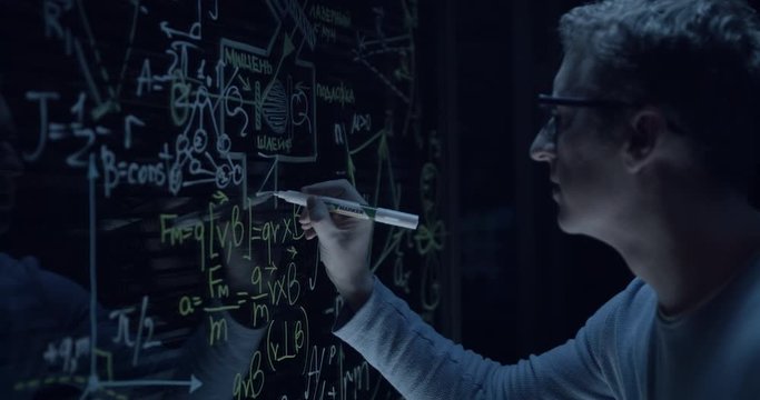 scientist at work writes the formula on the glass