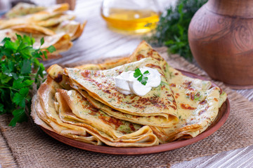Thin pancakes with herbs and sour cream