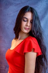 Fototapeta premium black hair woman portrait with brown eyes on a gray background , Caucasian ethnic group is looking into the camera with a serious expression on her face. White girl with long black hair and brown eye