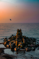 view of the sea or ocean at sunrise or sunset in quiet weather with sea stones and sand