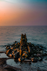 view of the sea or ocean at sunrise or sunset in quiet weather with sea stones and sand