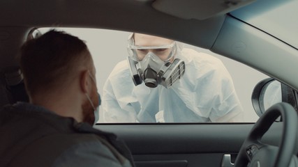 Patient is being tested in his vehicle on a drive-through coronavirus COVID-19 testing location. Pandemic, infection