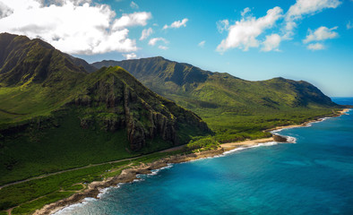 Aerial drone shot of mountains in Hawaii. Sun, clouds, shore, beach and ocean. Perfect nature from above